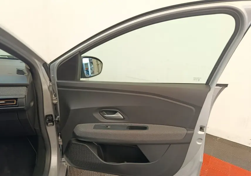 Vue intérieure de la porte avant gauche gris clair d'une Dacia Sandero Expression EGO-G 100 2023, avec garniture noire et tissu gris.