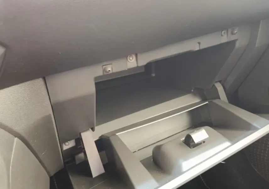 Gros plan sur la boîte à gants ouverte côté passager de la Dacia Sandero Expression gris clair 2023.