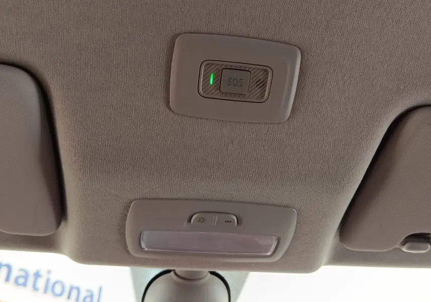 Intérieur du plafond avant de la Dacia Sandero gris clair 2023, avec bouton SOS et éclairage plafonnier visible.
