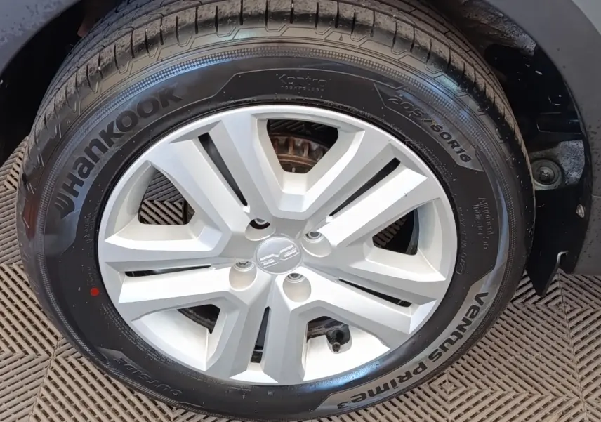 Gros plan sur la roue avant droite de la Dacia Sandero gris clair, avec jante en alliage et pneu Hankook.