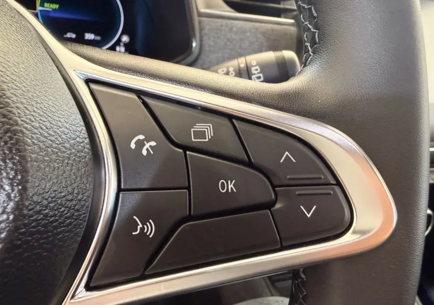 Gros plan sur les commandes multifonctions du volant cuir noir de la Renault ZOE électrique 2024.