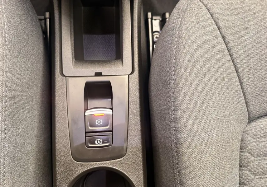 Gros plan sur la console centrale noire avec frein à main électrique et siège tissu gris Renault ZOE 2024.