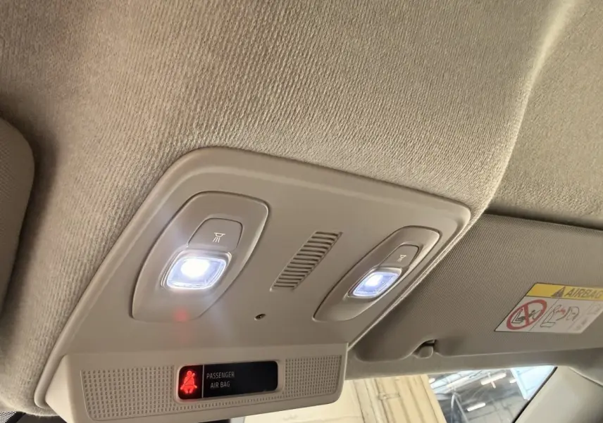 Plafonnier intérieur avec éclairage LED blanc et témoin airbag passager actif dans une Renault ZOE noire.