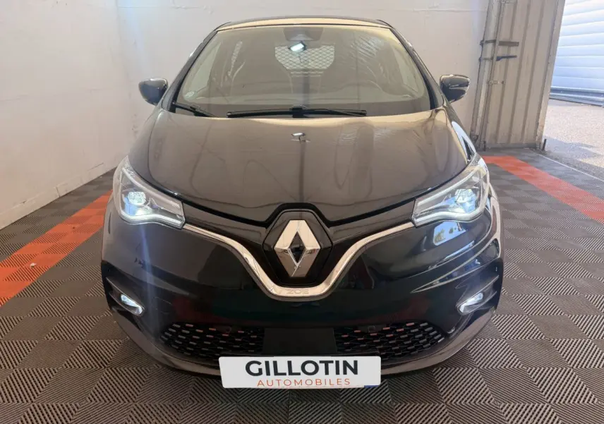 Vue avant d'une Renault ZOE noire électrique 2024 avec phares LED allumés et logo Renault bien visible.