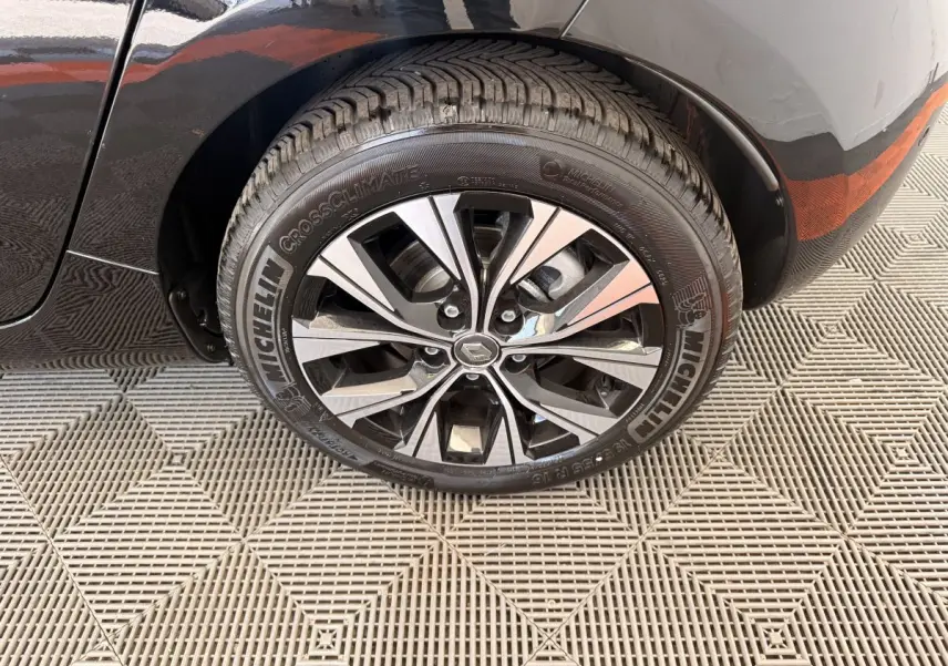 Gros plan sur la roue arrière gauche noire d'une Renault ZOE 2024 avec jante alliage et pneu Michelin.