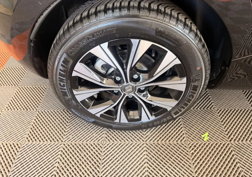 Gros plan sur la roue avant gauche noire de la Renault ZOE 2024 avec jante alliage bicolore et pneu Michelin.