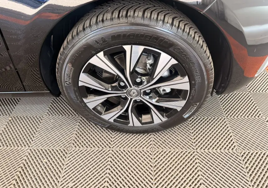 Gros plan sur la roue avant droite noire de la Renault ZOE 2024 avec jante alliage bicolore et pneu Michelin.