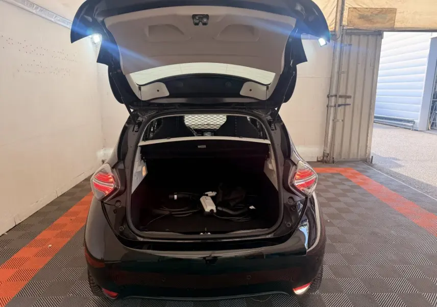 Vue arrière d'une Renault ZOE noire 2024 avec coffre ouvert et câble de charge visible à l'intérieur.