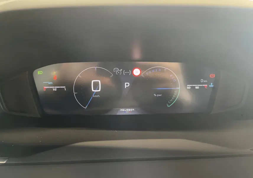 Affichage numérique du combiné de bord Peugeot 2008 hybride, montrant vitesse, mode et jauges énergie en veille.