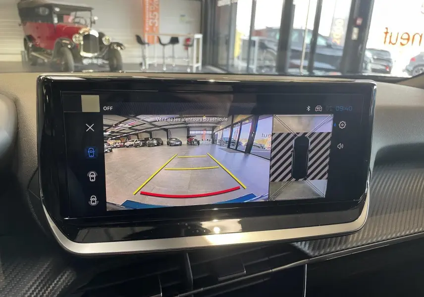 Écran tactile intérieur montrant la caméra de recul et la vue 360° du Peugeot 2008 hybride bleu en stationnement.