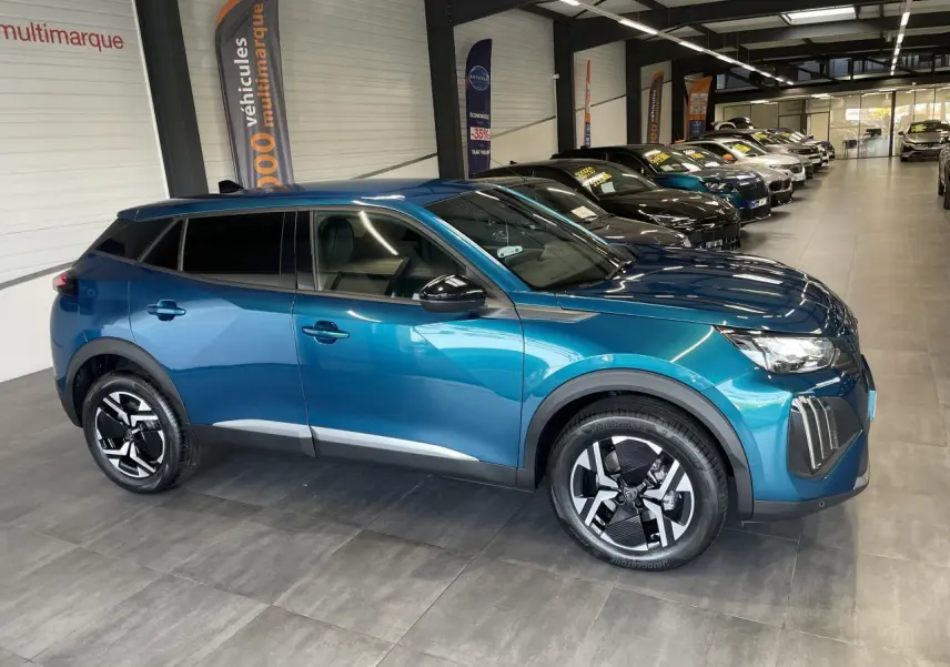 Peugeot 2008 bleu 3/4 avant droit en showroom, jantes alliage bicolores et vitres teintées.
