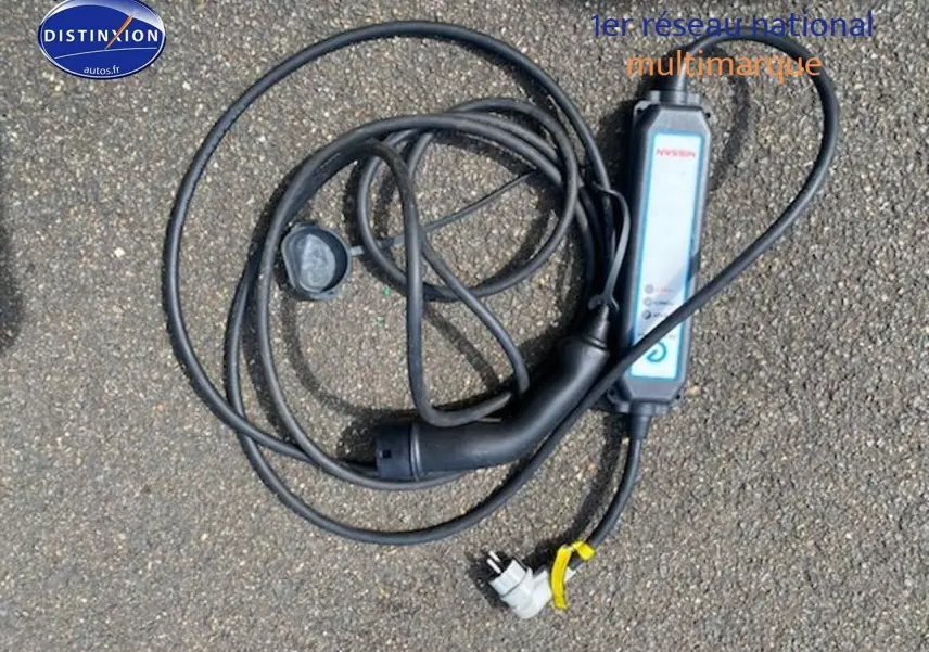 Câble de recharge noir pour Nissan Leaf électrique 40kWh Acenta posé au sol sur un sol goudronné.