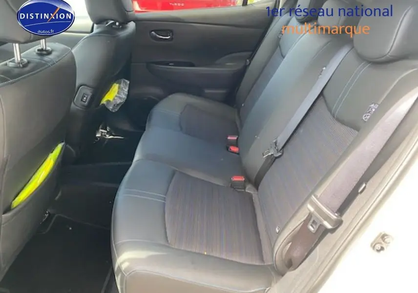 Vue intérieure sur les sièges arrière en tissu et cuir d'une Nissan Leaf électrique blanc nacré, côté droit ouvert.