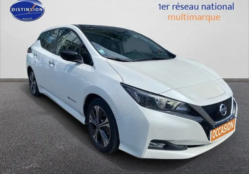 Nissan Leaf électrique blanc nacré vue 3/4 avant gauche avec jantes alliage et calandre noire distinctive.