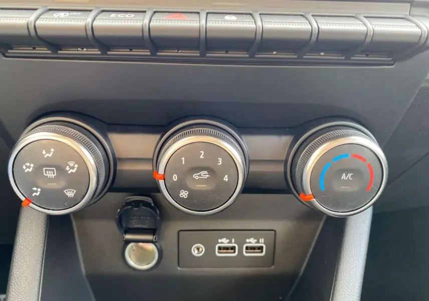 Gros plan sur les commandes de climatisation manuelle et les ports USB de la Renault Clio 1.5 Blue dCi gris schiste.