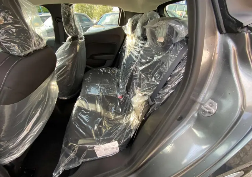 Vue intérieure côté droit de la banquette arrière d'une Renault Clio 2025 gris schiste avec sièges protégés par film plastique.