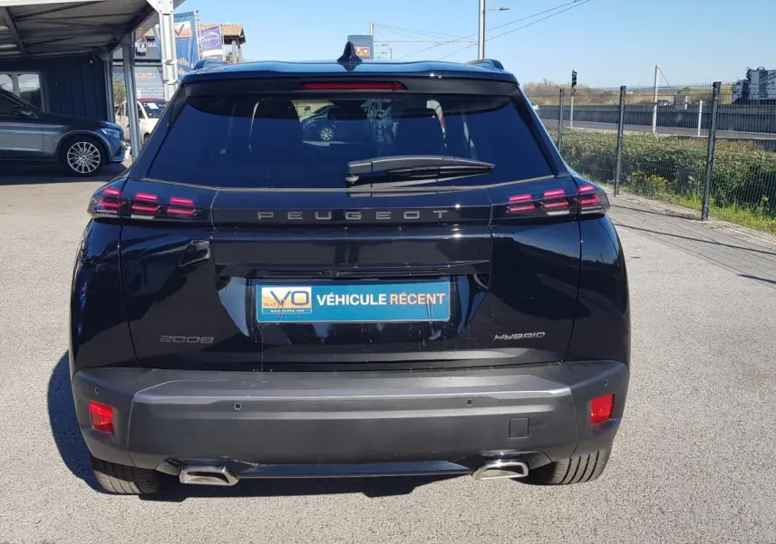Vue arrière d'un Peugeot 2008 Hybrid noir de 2025 avec feux LED et double sortie d'échappement visible.