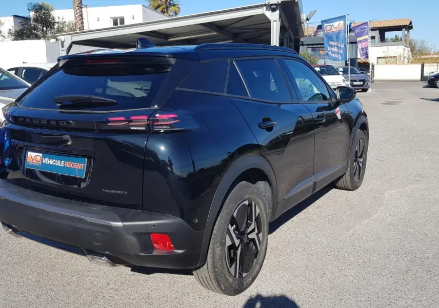 Vue 3/4 arrière droite d’un Peugeot 2008 Hybrid 145 noir avec jantes alliage 17 pouces et feux arrière LED distinctifs.
