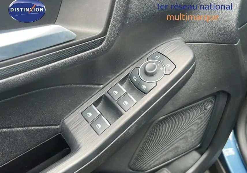 Détail des commandes de lève-vitres et rétroviseurs sur la porte côté conducteur d’un Ford Kuga bleu chrome 2024.