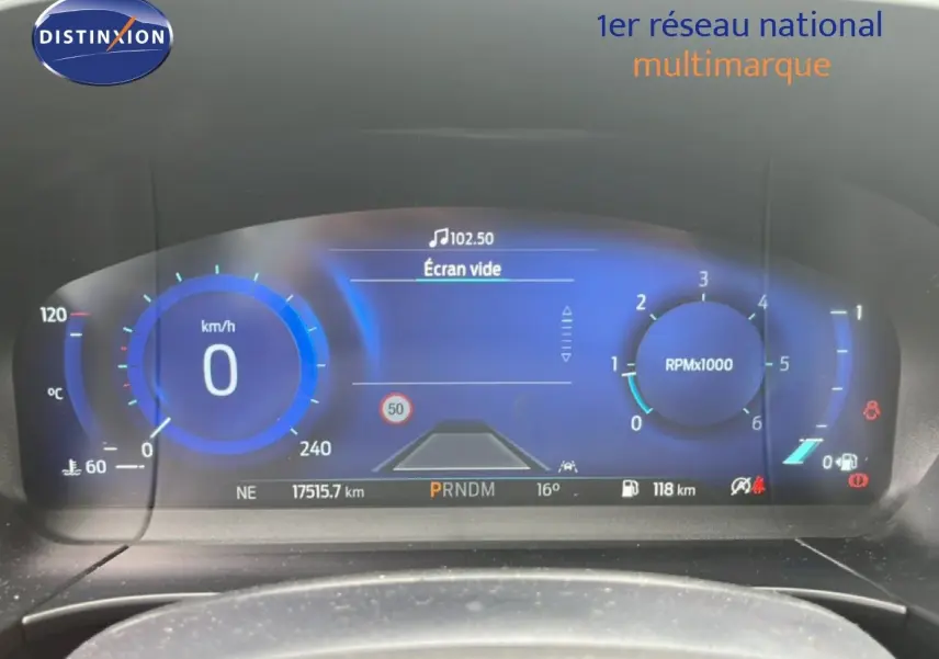 Tableau de bord numérique du Ford Kuga 2024 bleu chrome, affichage vitesse et compte-tours en vue frontale.