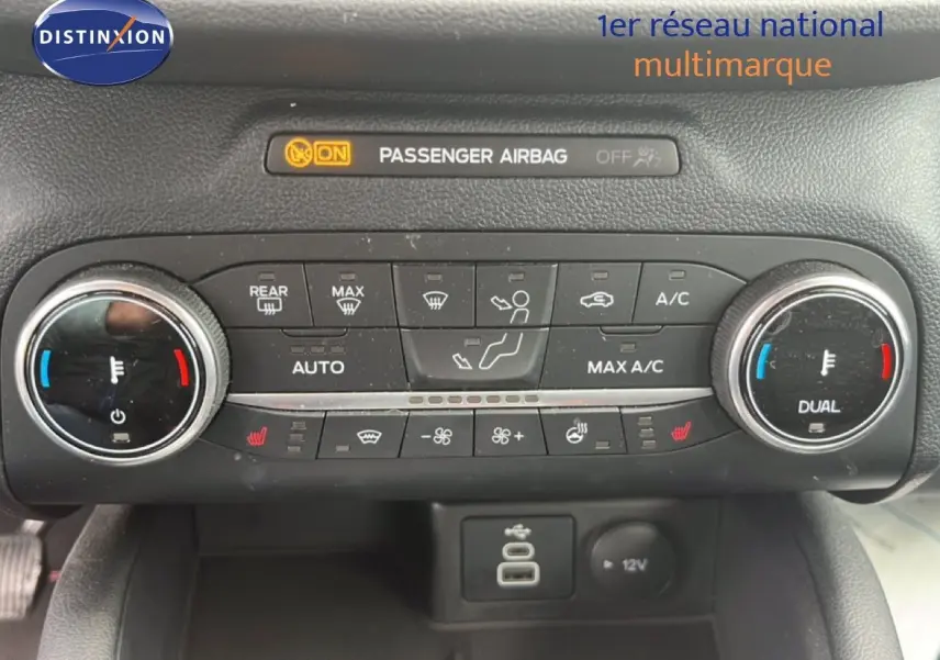 Vue rapprochée du tableau de bord du Ford Kuga 2024 bleu chrome, montrant les commandes de climatisation et chauffage.