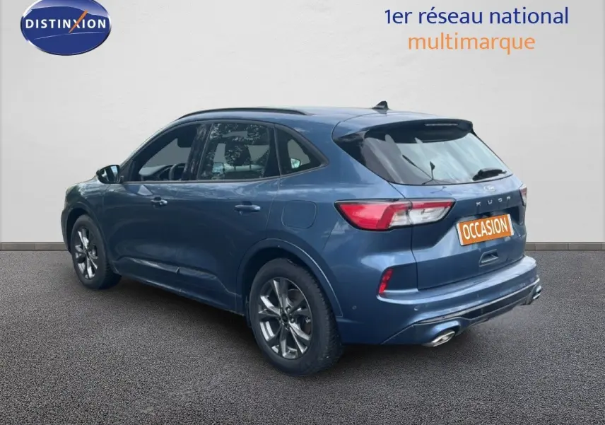 Vue 3/4 arrière droite d'un Ford Kuga 2024 bleu chrome métal avec finition ST-LINE et double sortie d'échappement.