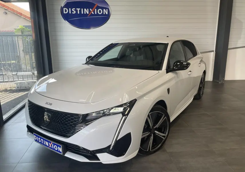 Peugeot 308 GT blanche vue en 3/4 avant droit, avec calandre noire vernie et jantes alliage 18 pouces.