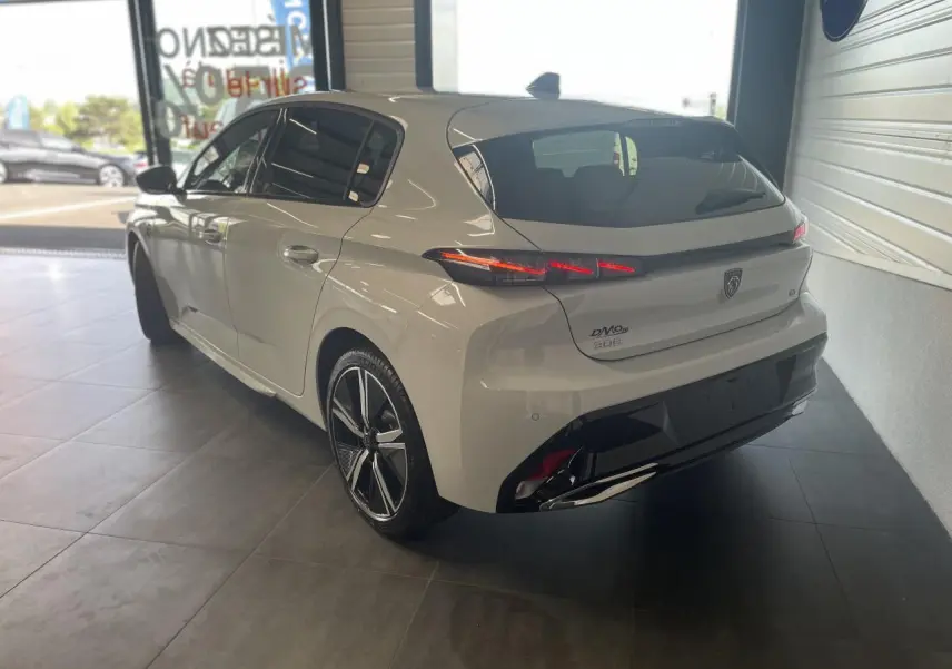 Vue 3/4 arrière droite d'une Peugeot 308 blanche avec feux arrière LED griffés et jantes alliage 18 pouces.