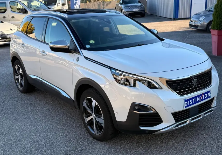 Vue 3/4 arrière droite d'un Peugeot 3008 blanc nacré avec feux arrière à trois griffes et jantes alliage bicolores.