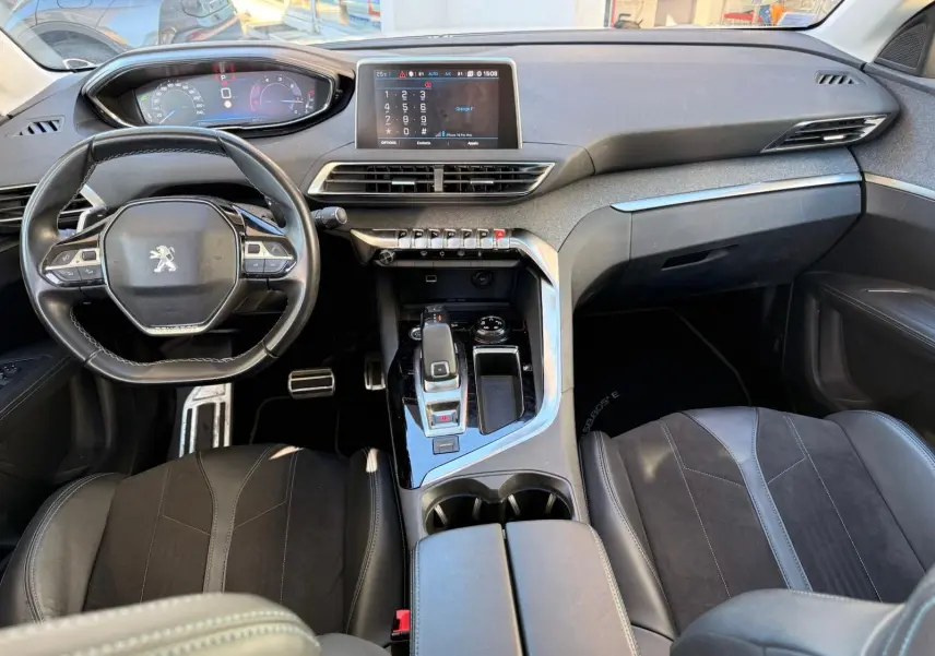 Intérieur du Peugeot 3008 2019, vue côté conducteur, sièges en cuir noir avec surpiqûres blanches et toit ouvrant panoramique.