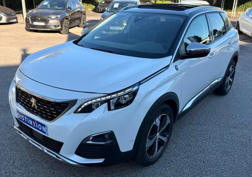 Vue rapprochée du toit ouvrant panoramique et du côté droit du Peugeot 3008 blanc nacré stationné en extérieur.