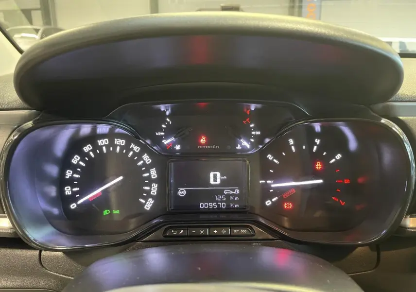 Vue rapprochée du tableau de bord numérique de la Citroën C3 beige clair 2024, affichant vitesse et compteurs.