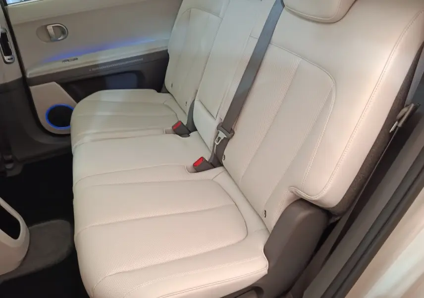 Vue latérale des sièges arrière beige clair en cuir perforé de la Hyundai IONIQ BEV 77KWH AWD Executive 2023.