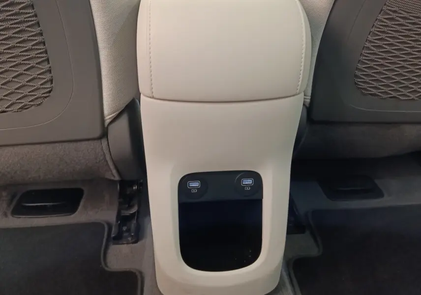 Vue rapprochée de la console arrière beige du Hyundai IONIQ 2023 avec deux ports USB visibles entre les sièges avant.