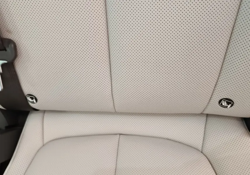 Gros plan sur la banquette arrière beige perforée du Hyundai IONIQ 2023 avec fixation ISOFIX visible.