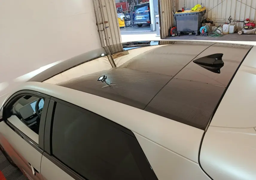 Vue en plongée côté gauche d'une Hyundai IONIQ beige 2023 avec toit panoramique noir et antenne requin.