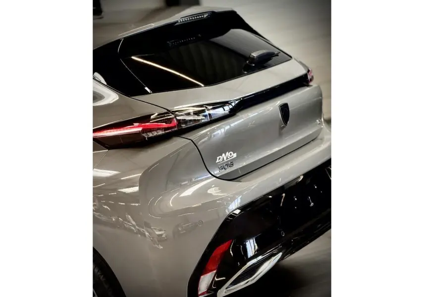 Vue 3/4 arrière droite d'une Peugeot 308 gris selenium avec feux arrière à signature lumineuse griffe à griffe.