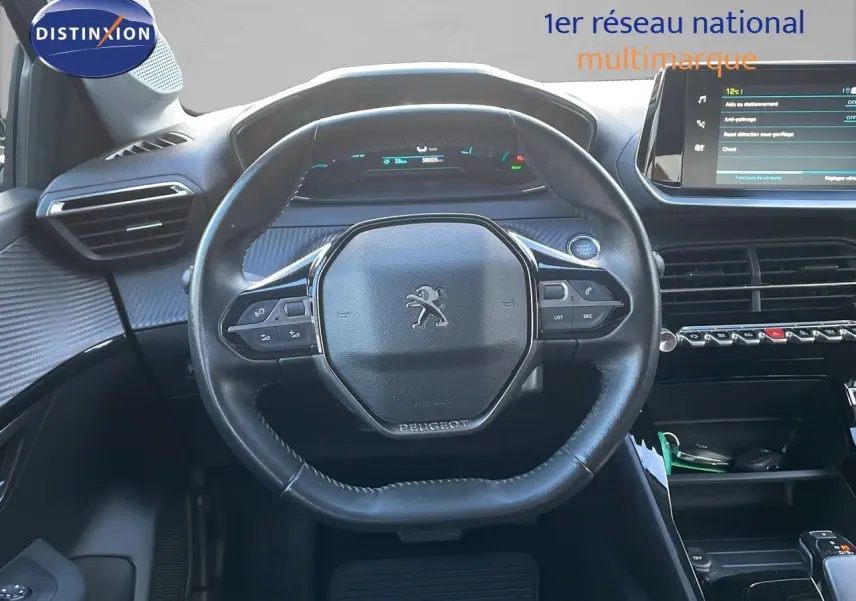 Vue centrée sur le volant cuir noir du Peugeot 208 électrique 2020 avec tableau de bord digital et écran tactile.