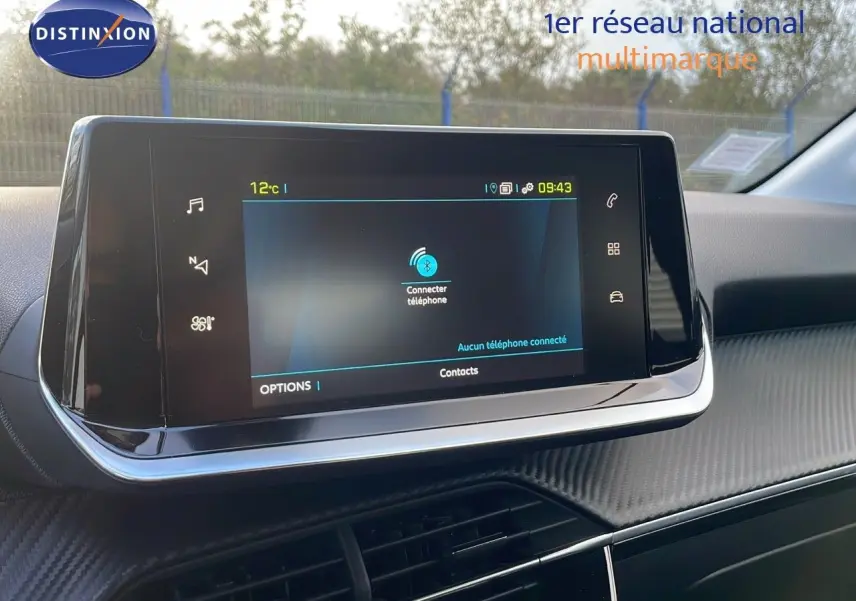 Écran tactile central du tableau de bord de la Peugeot 208 électrique gris Artense, affichant la connexion Bluetooth.