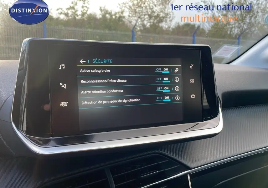 Écran tactile central affichant les options de sécurité dans l'habitacle d'une Peugeot 208 électrique gris Artense.