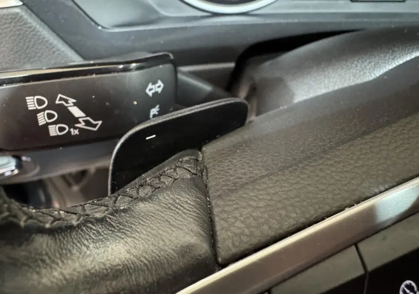 Gros plan sur le levier de vitesse et palettes au volant en cuir noir du Volkswagen Tiguan bleu 2021.