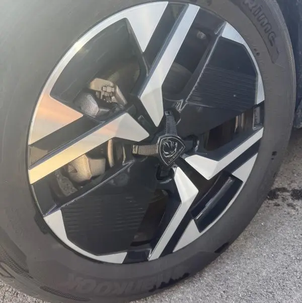 Gros plan sur la jante alliage 17 pouces noire et argentée du Peugeot 2008 Hybrid 145 e-DCS6 Allure gris.