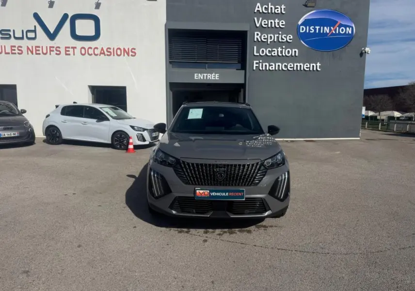 Peugeot 2008 Hybrid 145 gris vue de face, calandre verticale noire et feux LED en forme de griffes.