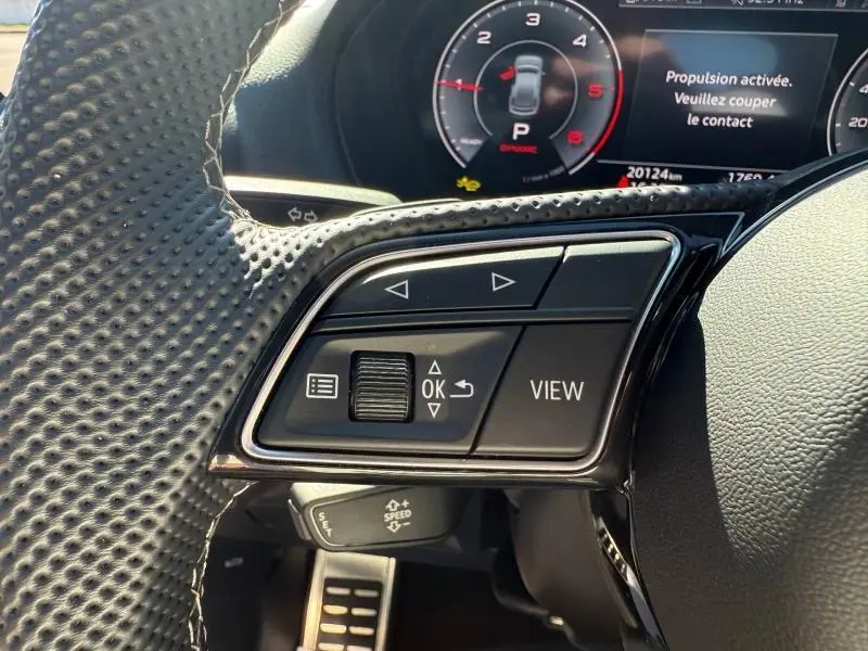 Gros plan sur les commandes au volant et le tableau de bord digital d’un Audi Q2 35 TDI S line 2025.