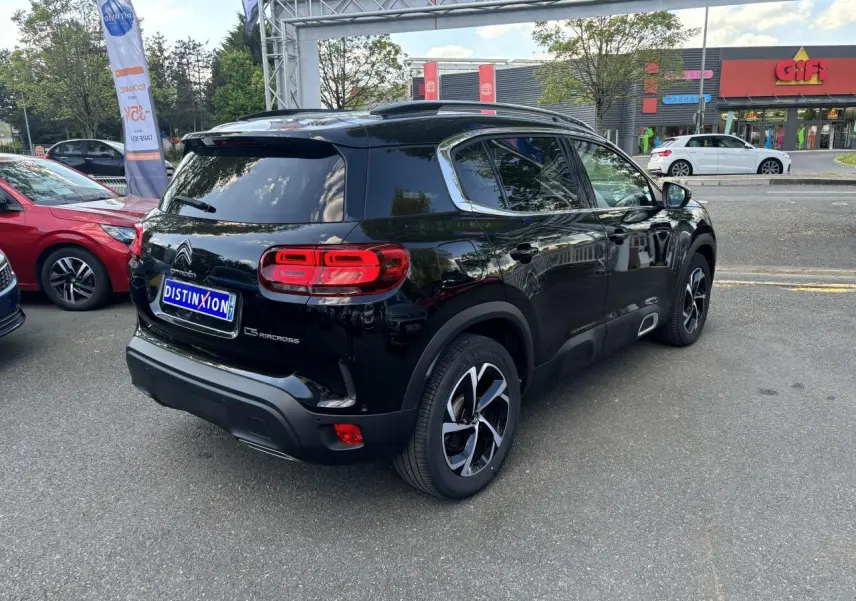 Vue 3/4 arrière droite d'un Citroën C5 Aircross noir métallisé avec feux arrière LED et vitres surteintées.