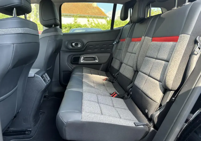Vue intérieure arrière côté droit du Citroën C5 Aircross 2019 noir, montrant les sièges arrière gris avec bande rouge.