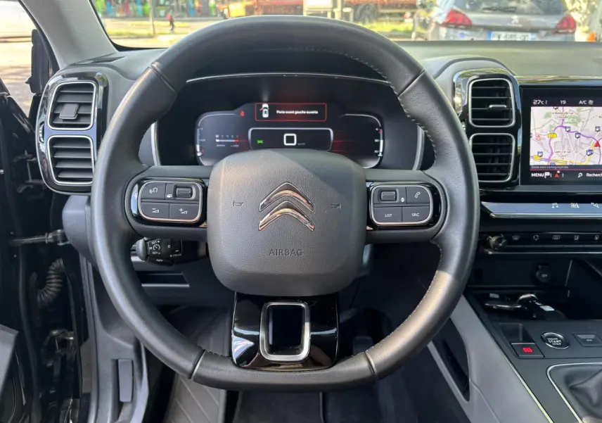 Vue frontale du volant et tableau de bord numérique du Citroën C5 Aircross noir métallisé avec écran tactile de navigation.