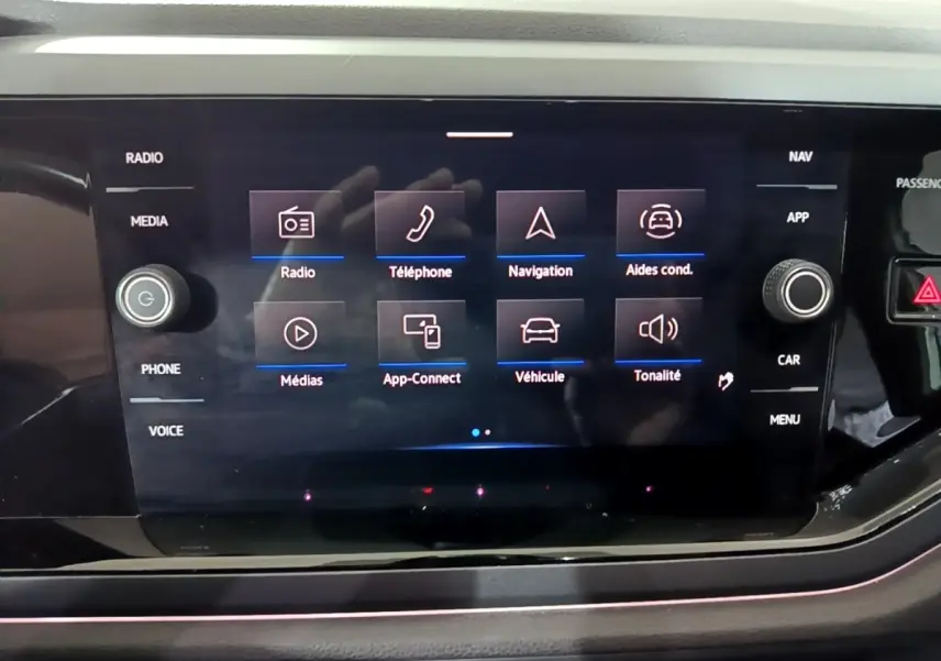 Vue rapprochée de l'écran tactile central du Volkswagen Taigo blanc, affichant le menu multimédia et navigation.