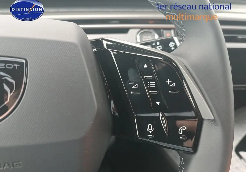 Gros plan sur les commandes vocales et audio au volant cuir du Peugeot 5008 Hybrid 145 gris Artense, côté gauche.