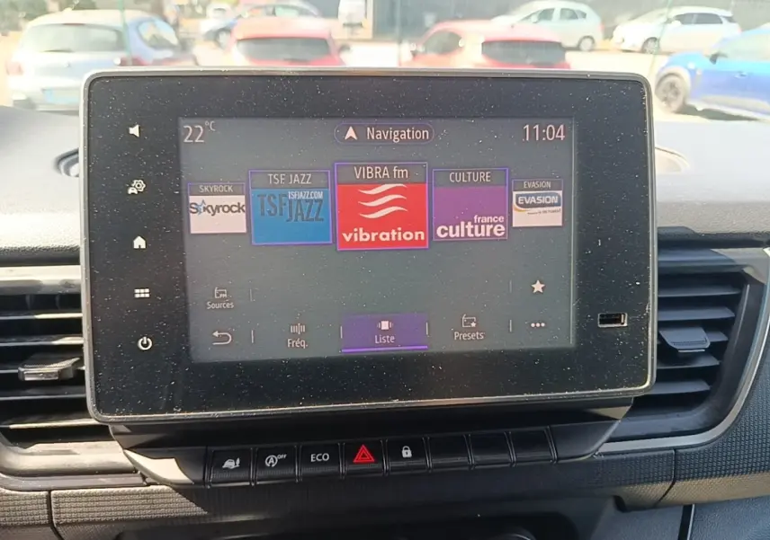 Écran tactile central du Renault Trafic Fourgon blanc 2023 affichant les stations radio, vue intérieure avant.